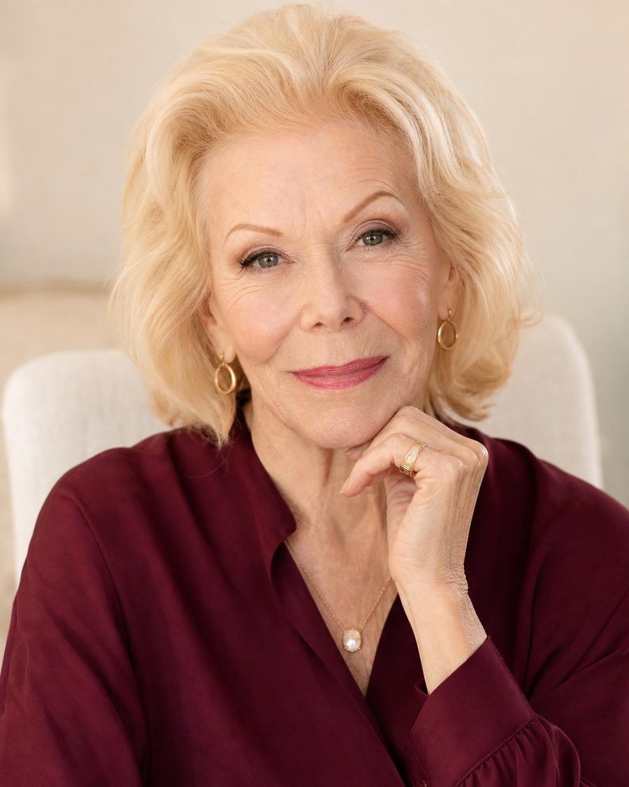 Louise Hay, author of You Can Heal Your Life and founder of the Heal Your Life® philosophy, photographed in a burgundy blouse with a warm, thoughtful expression